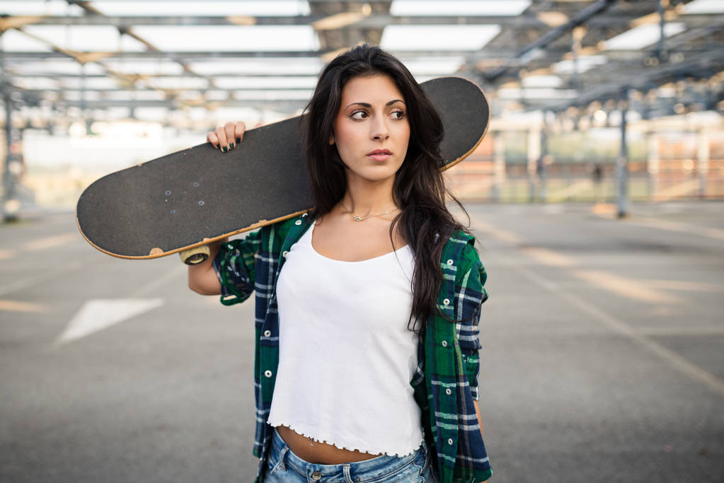Teenager with skateboard portrait outdoors in a parking area.  - Photo, Image