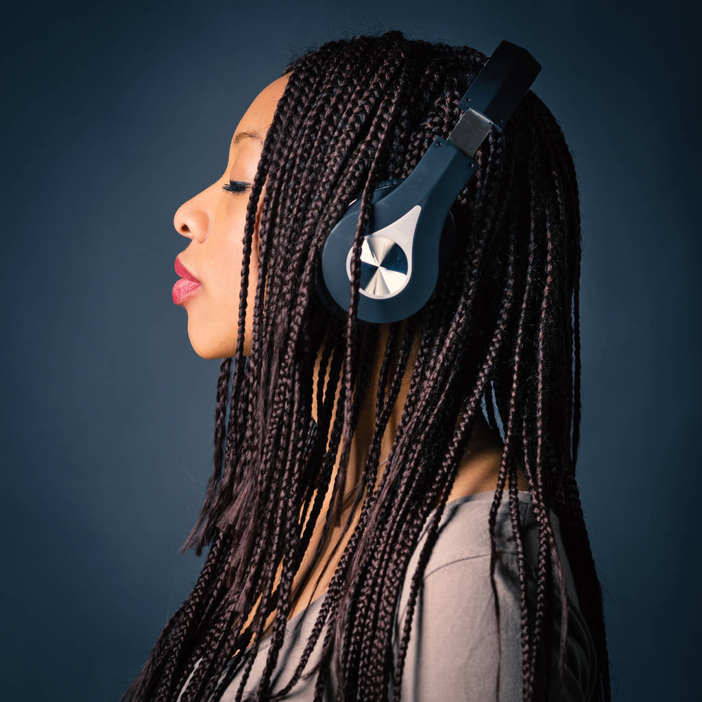Africaine jeune femme studio portrait avec tresses écoute mus
 - Photo, image