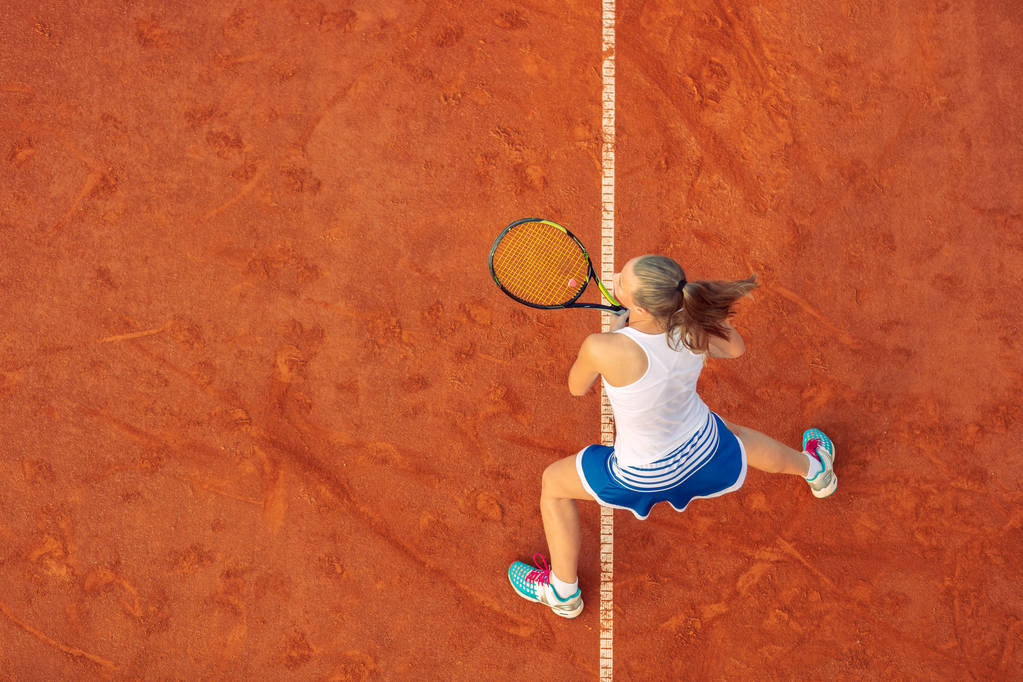 試合中にコート上の女子テニス選手の空中ショット。テニスをしている若い女性。高角ビュー. - 写真・画像
