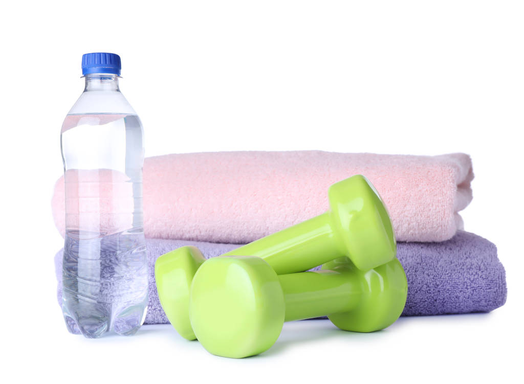 Des haltères élégants, une bouteille d'eau et des serviettes sur fond blanc. Fitness à domicile
 - Photo, image