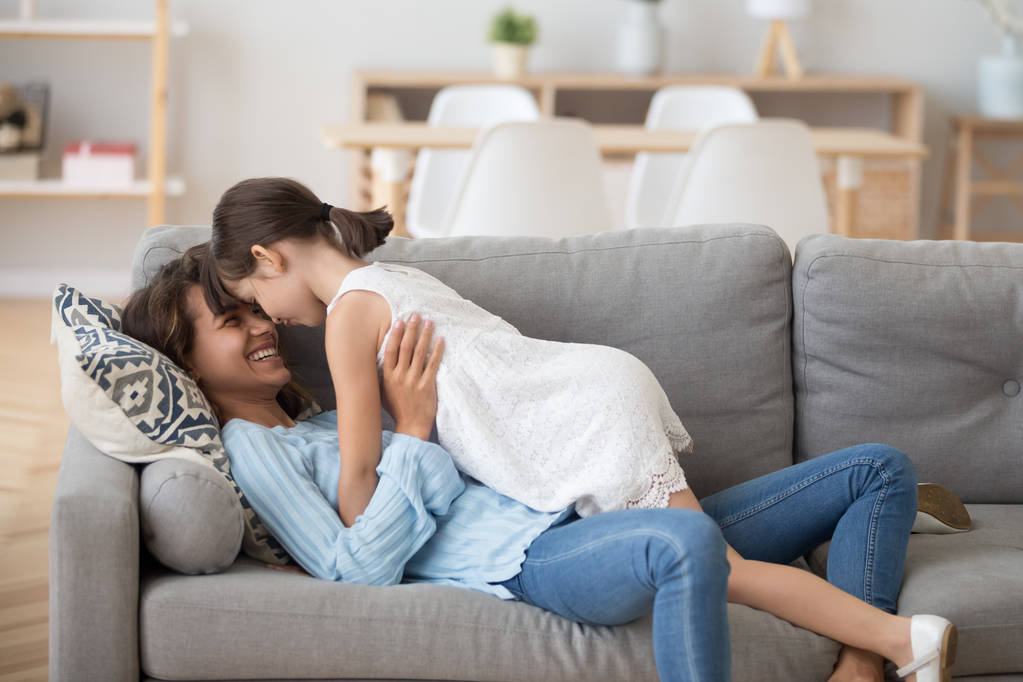 glücklich junge Mutter und Tochter umarmen sich entspannt zu Hause - Foto, Bild