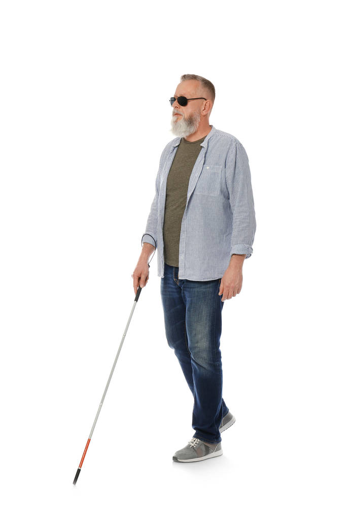 Зріла сліпа людина з довгою тростиною, що йде на білому тлі
 - Фото, зображення