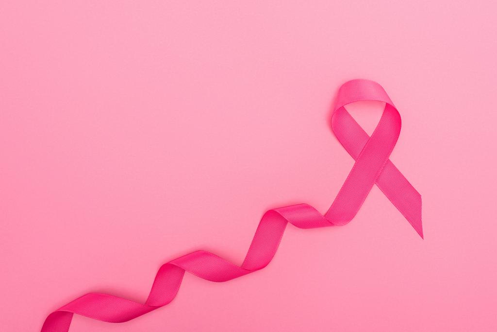 vista superior del signo de cáncer de mama carmesí curvado sobre fondo rosa
 - Foto, imagen