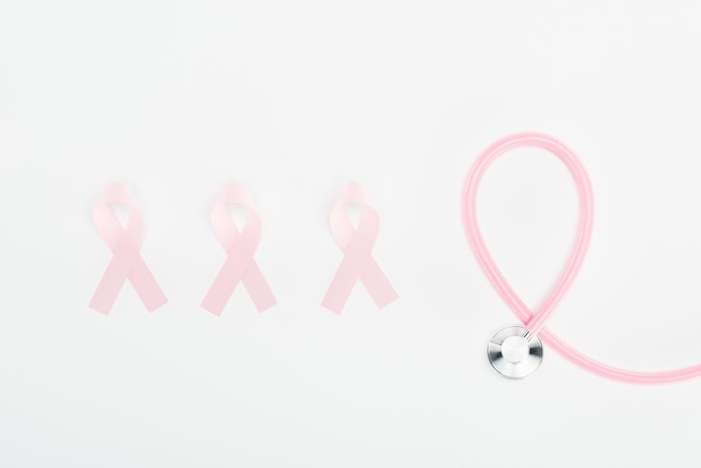 白い背景に聴診器とピンクの乳癌の兆候を持つ平らな横 - 写真・画像