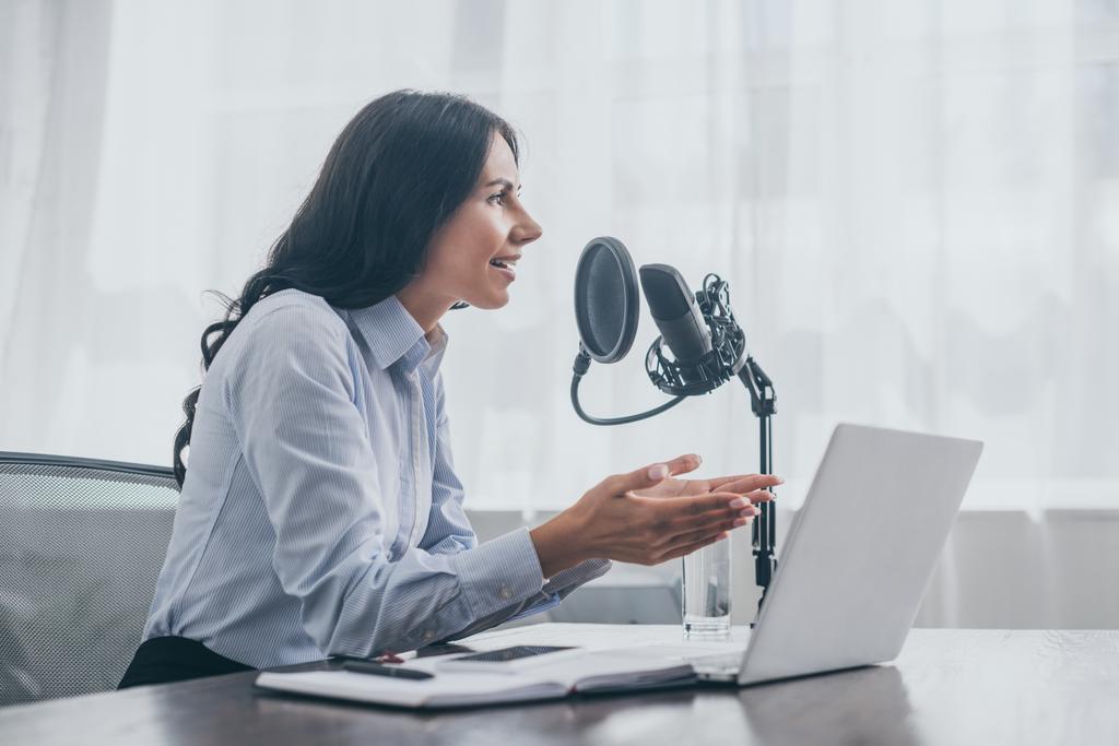 Lächelnder Radiomoderator gestikuliert während der Aufzeichnung eines Podcasts im Radiostudio - Foto, Bild