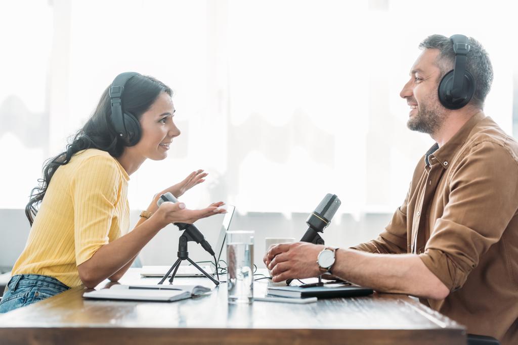 dva usmívající se hostitelé, kteří mluví při nahrávání podcastu v televizním studiu - Fotografie, Obrázek
