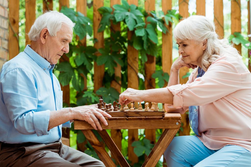nyugdíjas nő, szürke haja sakkozás a magas rangú férj  - Fotó, kép