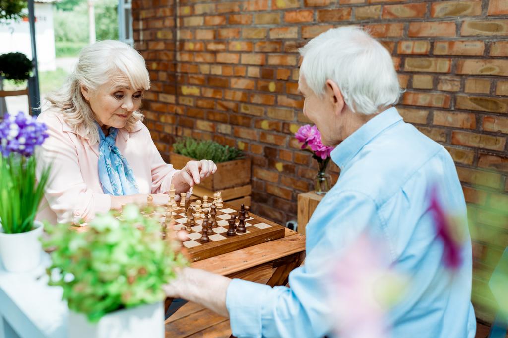 селективное внимание мужчины и женщины на пенсии, играющих в шахматы
  - Фото, изображение