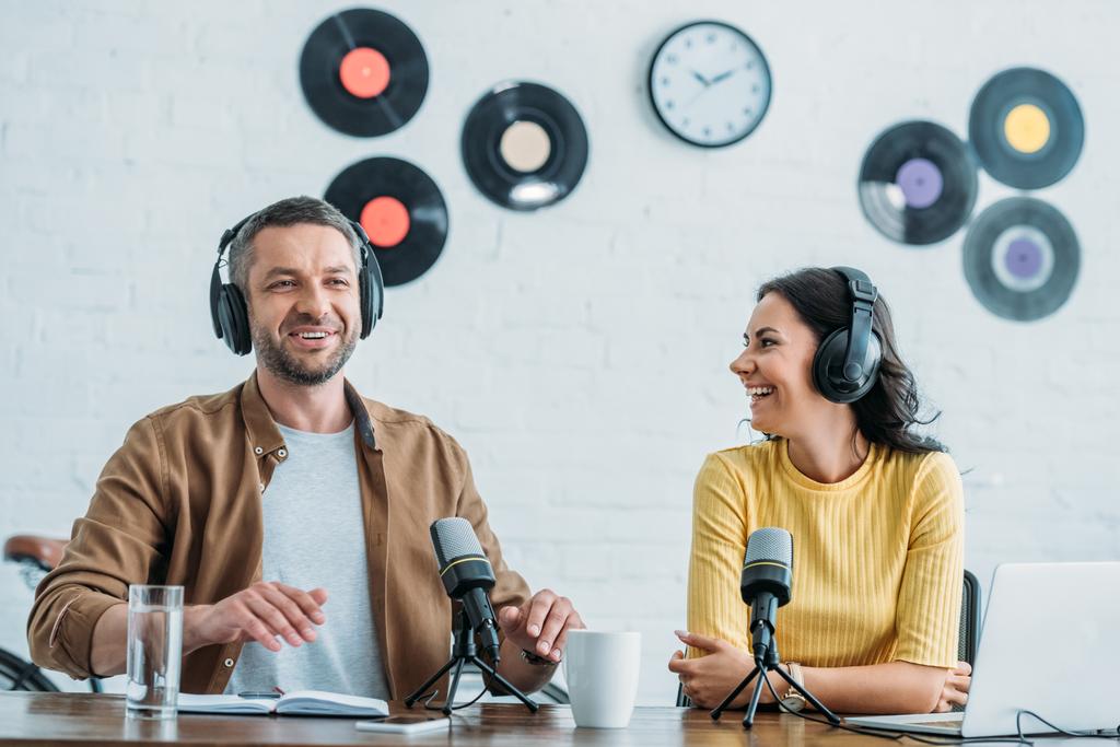 zwei gut gelaunte Radiomoderatoren im Kopfhörer, die gemeinsam einen Podcast im Studio aufnehmen - Foto, Bild