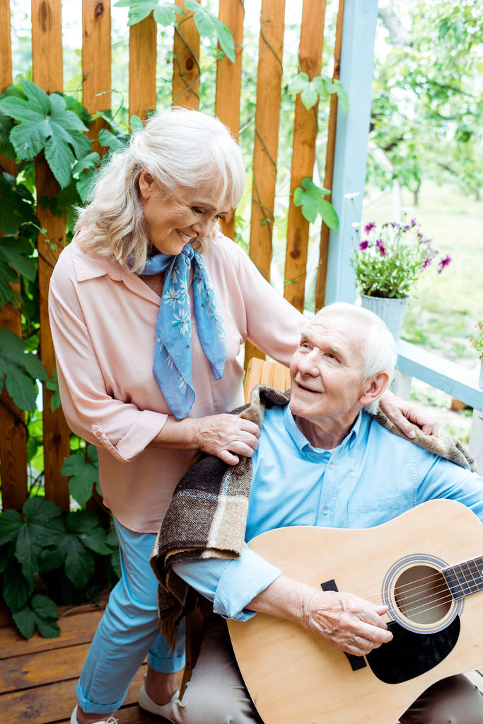 mari retraité joyeux jouant de la guitare acoustique près épouse heureuse
  - Photo, image
