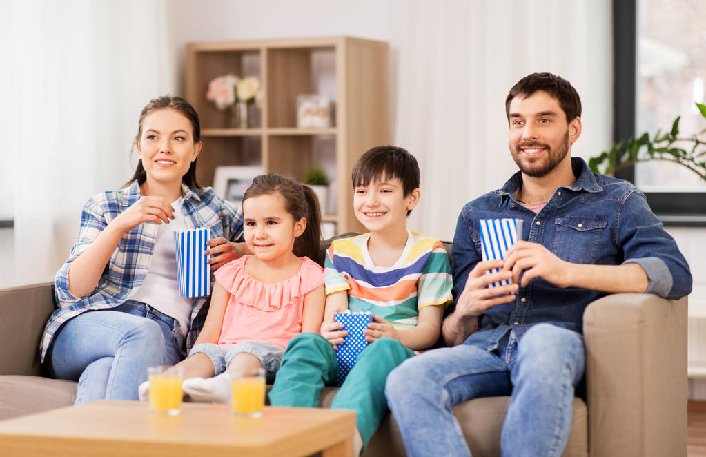evde tv izlerken patlamış mısır ile mutlu aile - Fotoğraf, Görsel