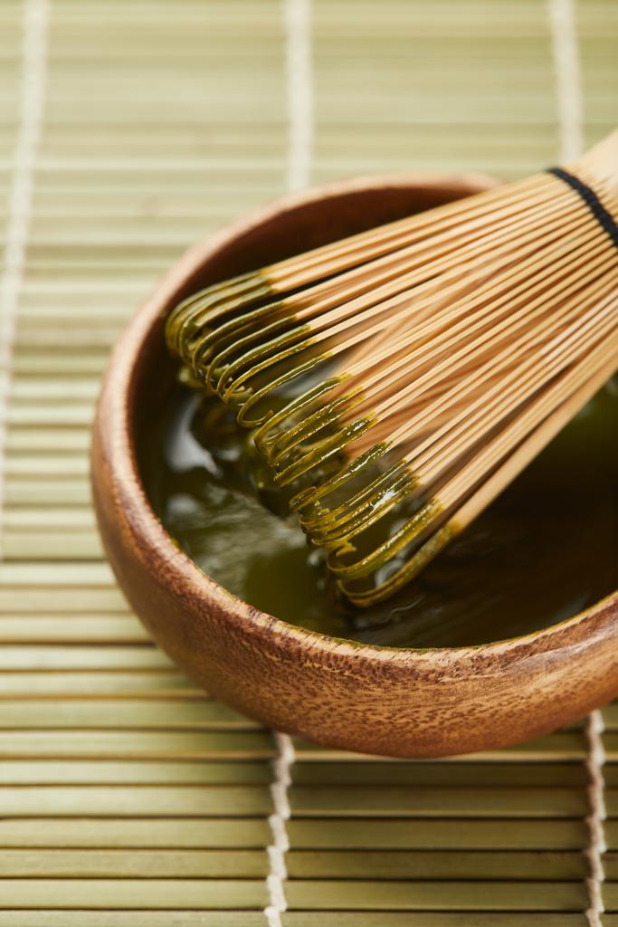 selektywne skupienie zielonego proszku Matcha i Bambus trzepaczka w drewnianej misce na stole mat - Zdjęcie, obraz