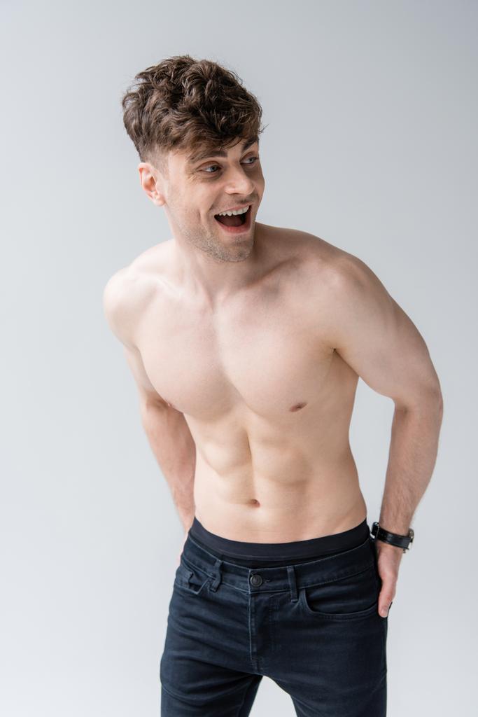 laughing shirtless muscular man looking away isolated on grey - Photo, Image