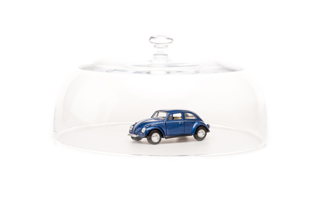 синій іграшковий автомобіль під скляним шафою ізольований на білому
 - Фото, зображення
