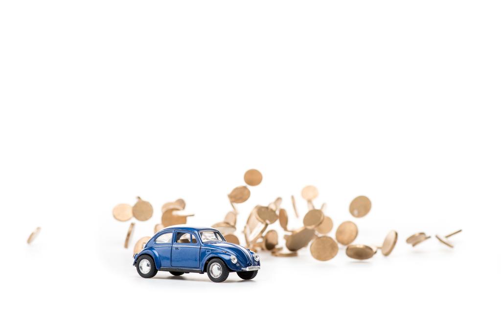 blaues Spielzeugauto und goldene Münzen auf weiß - Foto, Bild