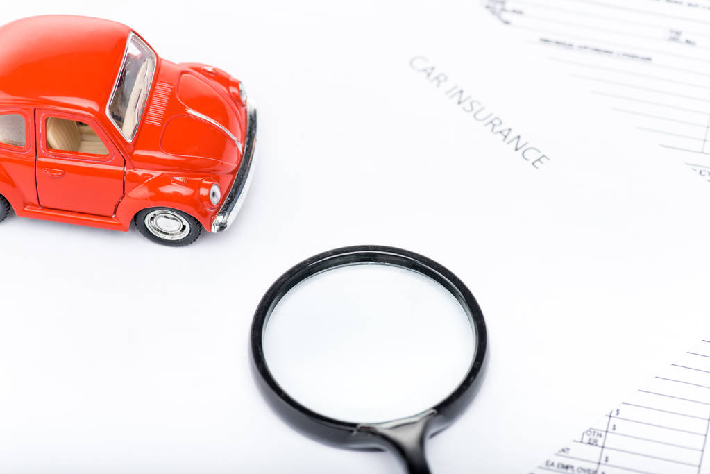 rode speelgoed auto, Vergrootglas en Verzekeringsdocumenten - Foto, afbeelding