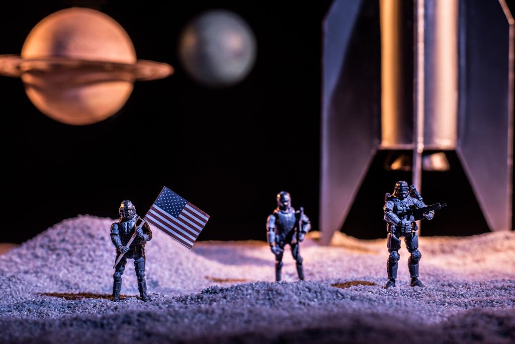 Zabawka żołnierzy posiadających amerykańską flagę w kosmosie w pobliżu rakiet i planet - Zdjęcie, obraz