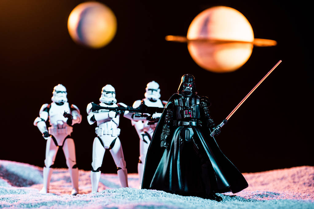 white imperial stormtroopers with guns and Darth Vader with lightsaber with planets on background - Foto, afbeelding