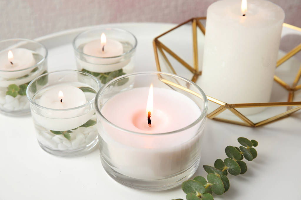 Samenstelling met brandende aromatische kaarsen en eucalyptus op tafel - Foto, afbeelding