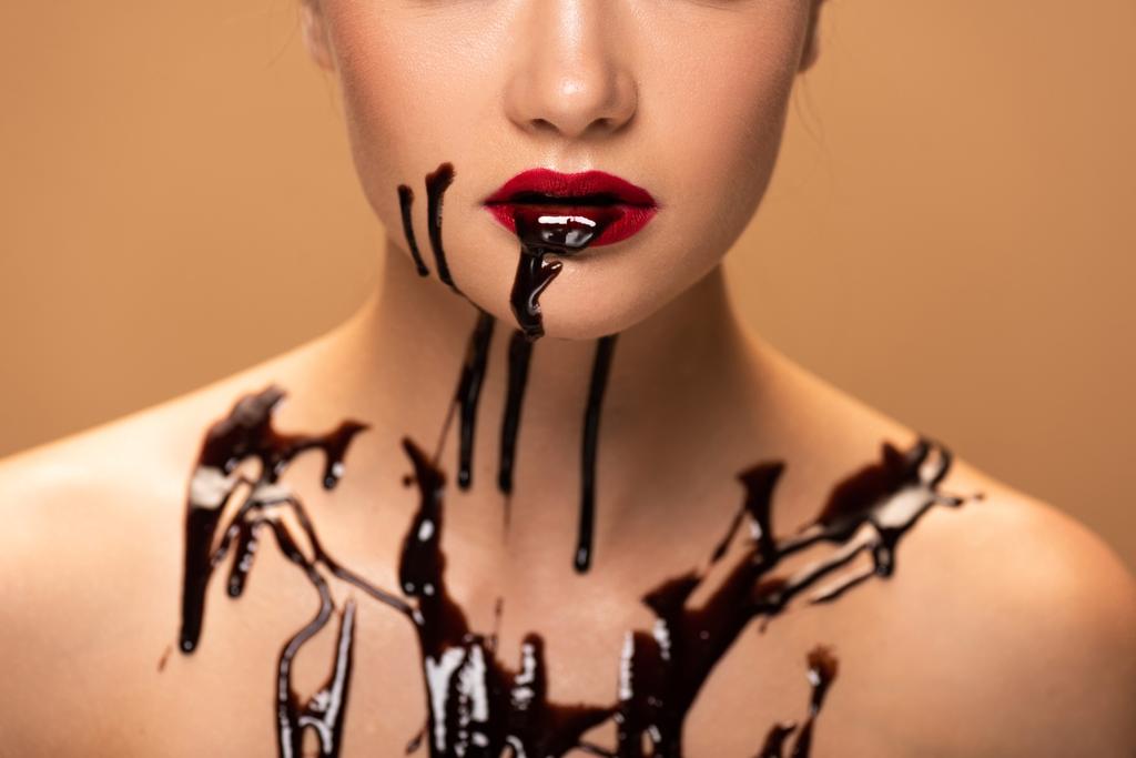 cropped view of naked woman with red lips and chocolate spills on skin isolated on beige - Photo, Image