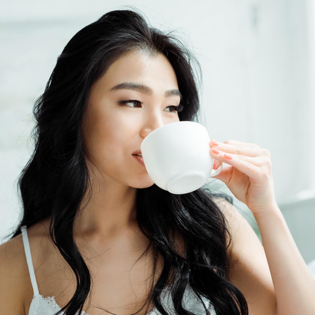 bella donna tailandese bere il tè mentre tiene in mano la tazza
  - Foto, immagini