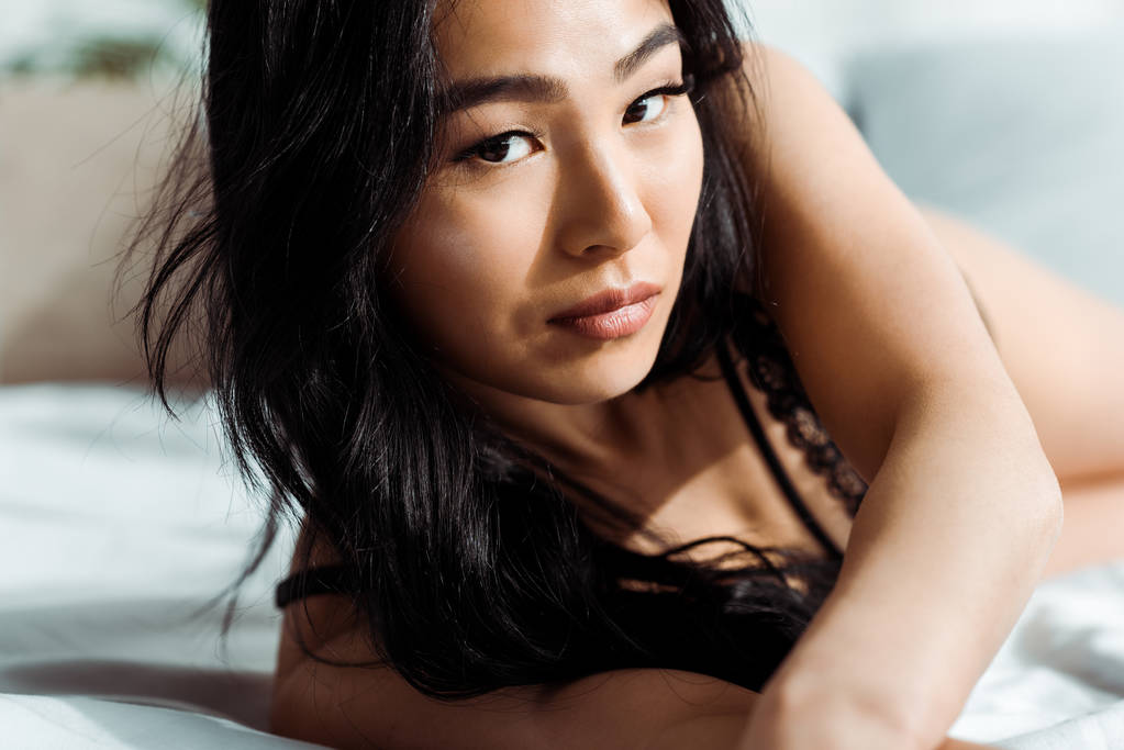 селективный фокус привлекательной брюнетки тайской женщины, смотрящей в камеру
 - Фото, изображение