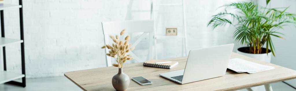 tiro panorâmico de laptop e smartphone em mesa de madeira no escritório moderno
  - Foto, Imagem