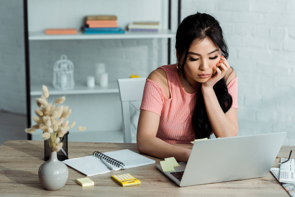 atractivo asiático chica usando laptop cerca notebook en oficina
  - Foto, imagen
