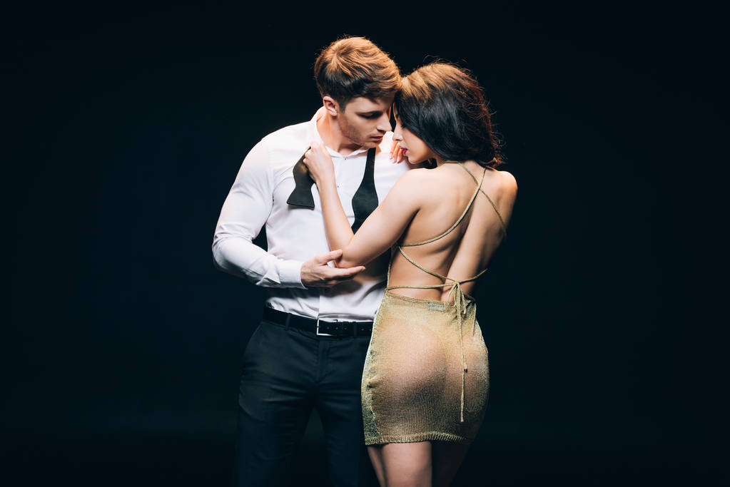 sexy elegant young couple touching each other isolated on black - Photo, Image