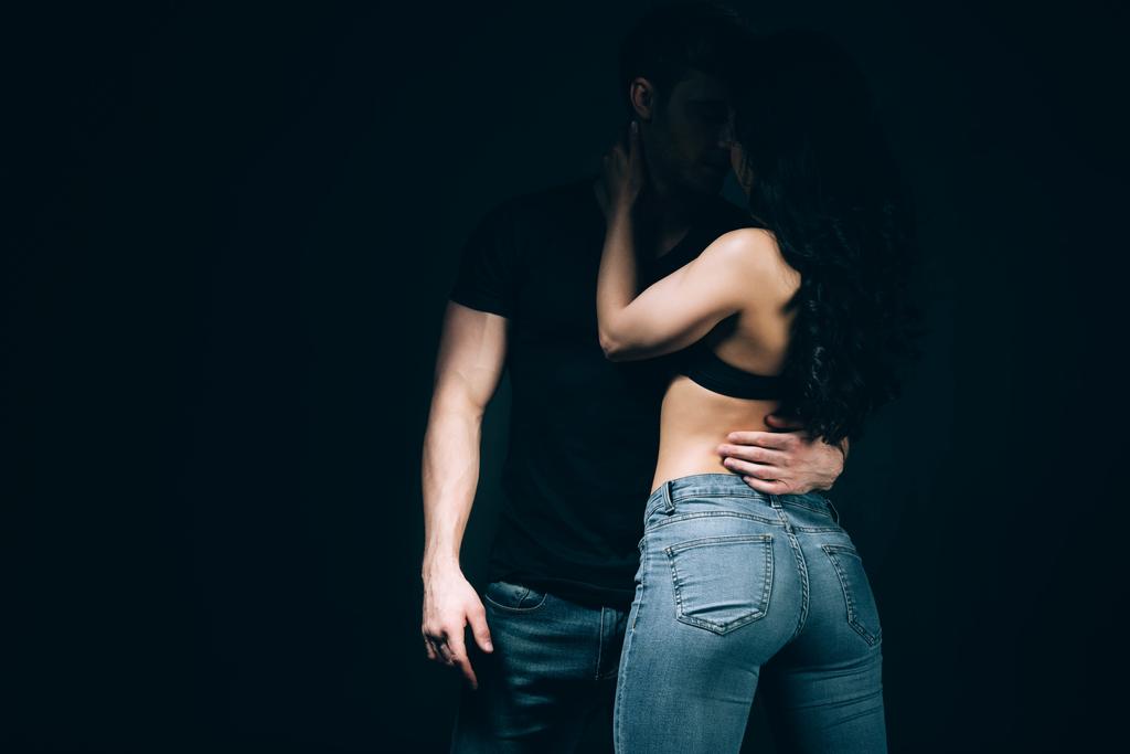 férfi csók barátnője melltartó és a farmer izolált fekete - Fotó, kép