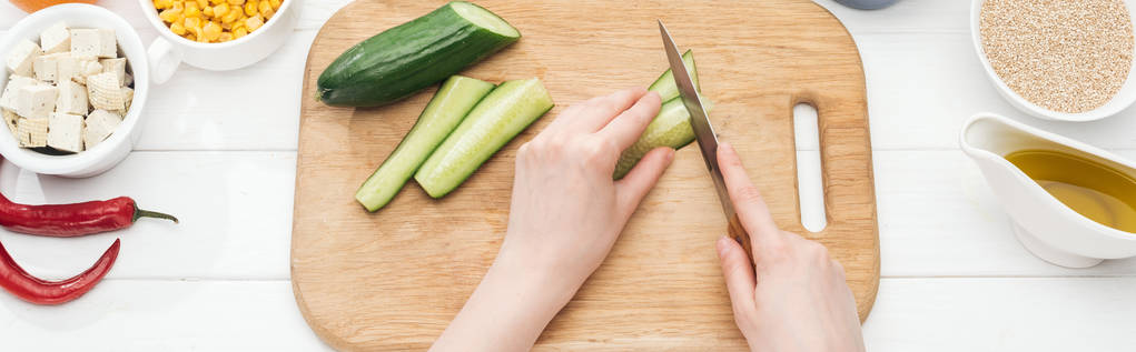 partial view of woman chopping cucumber on wooden white table, panoramic shot - Photo, Image