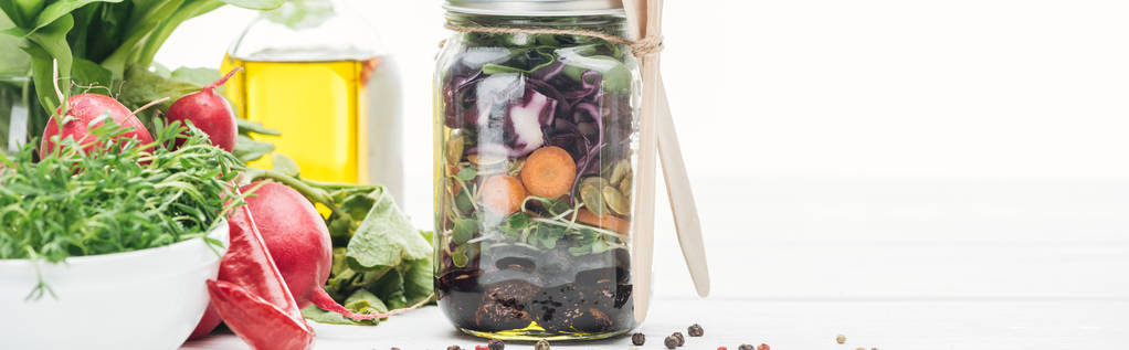 Свежий овощной салат в стеклянной банке рядом со специями и редис изолирован на белом, панорамный снимок
 - Фото, изображение