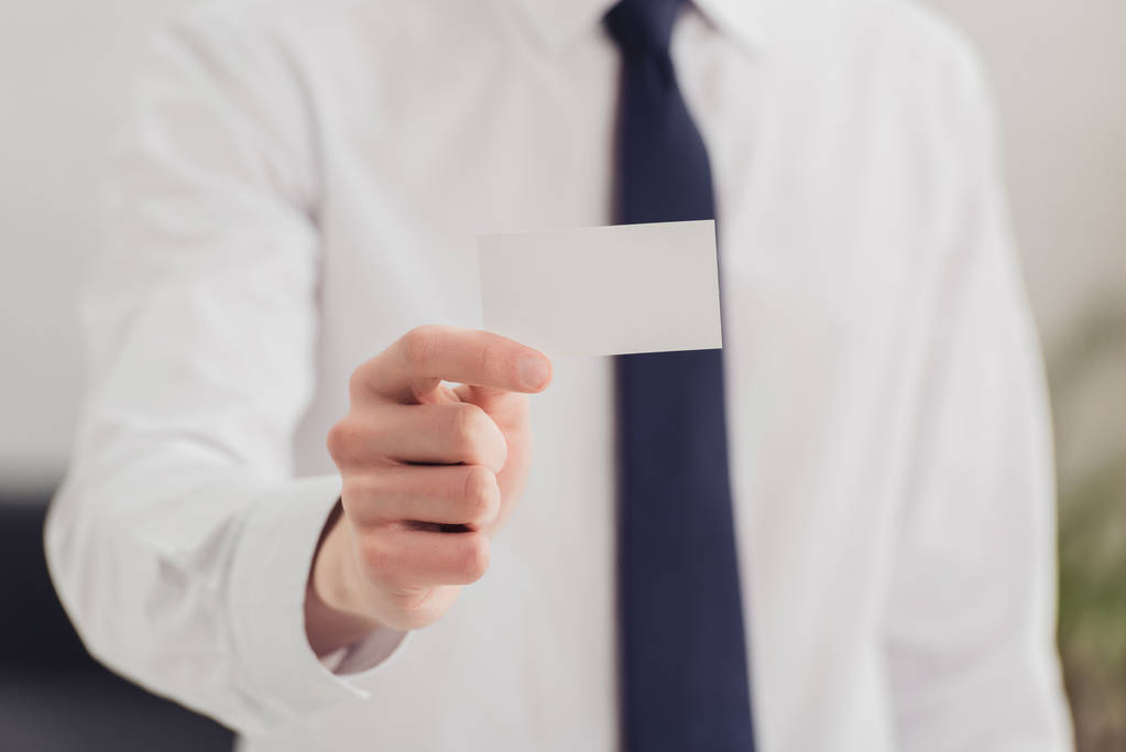 partial view of businessman showing at camera white blank business card - Photo, Image