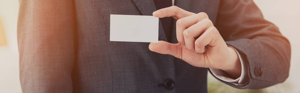 recortado vista de hombre de negocios sosteniendo blanco tarjeta de visita vacía, plano panorámico
 - Foto, Imagen