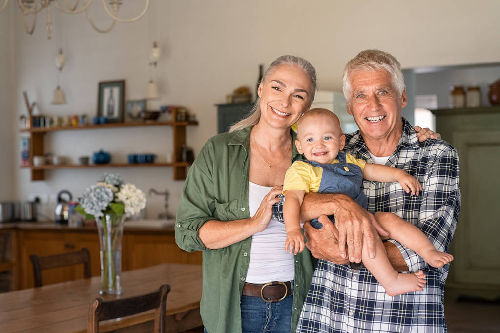 Boldog nagyszülők gazdaság mosolygó unoka - Fotó, kép