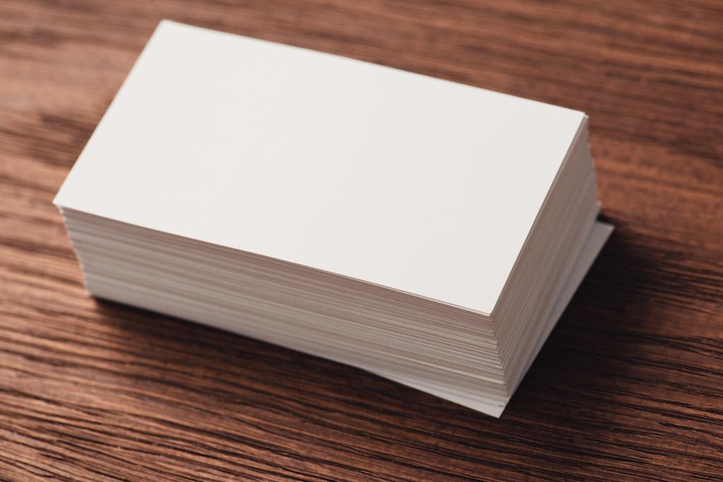 pila de tarjetas de visita blancas en blanco en la superficie de madera marrón
 - Foto, Imagen