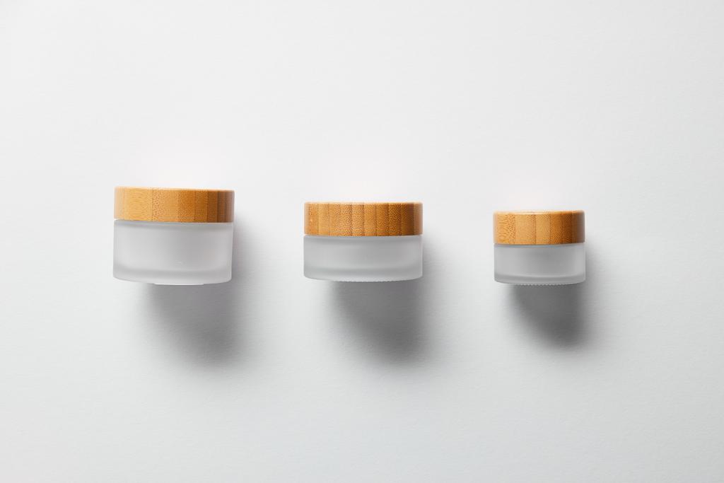 три порожні банки для ручного крему на білому
  - Фото, зображення