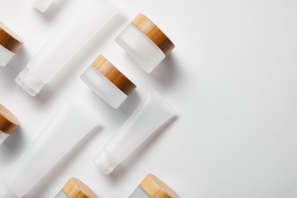 disposición plana de tubos de crema y frascos con tapas de madera en blanco
  - Foto, imagen