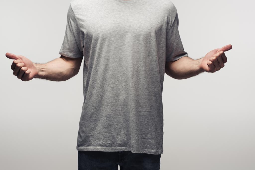 gedeeltelijke weergave van de man in grijs shirt met duimen omhoog geïsoleerd op grijs, menselijke emotie en expressie concept - Foto, afbeelding