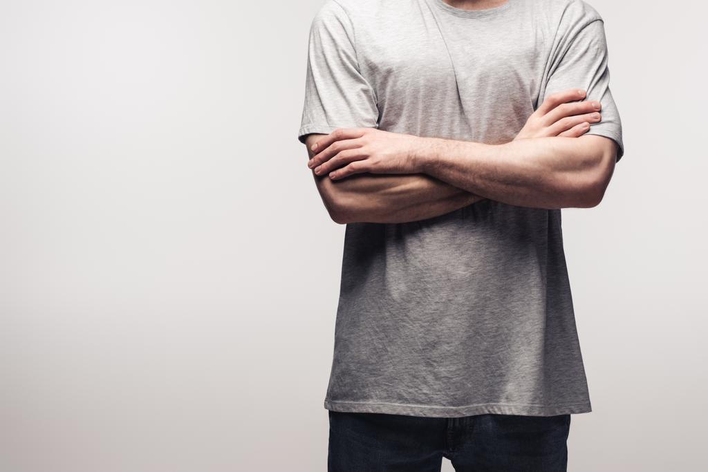 частичный взгляд человека в серой футболке, стоящего со скрещенными руками, изолированный от серого, человеческой эмоций и выражений
 - Фото, изображение