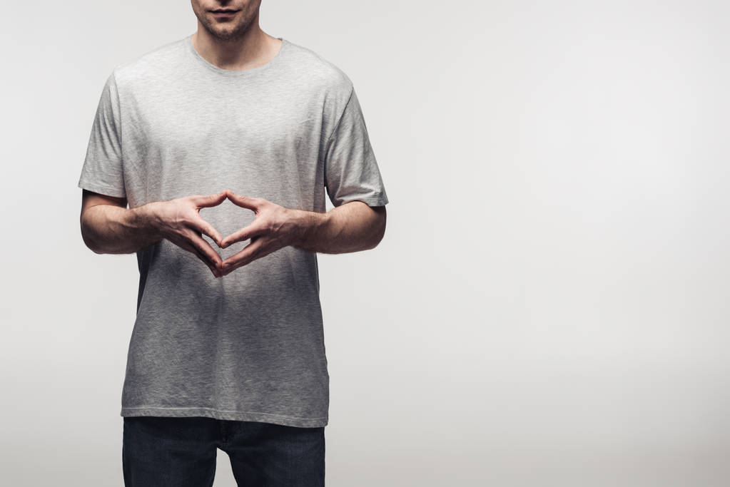 partial view of man in grey t-shirt showing steeple gesture while using body language isolated on grey, human emotion and expression concept - Photo, Image