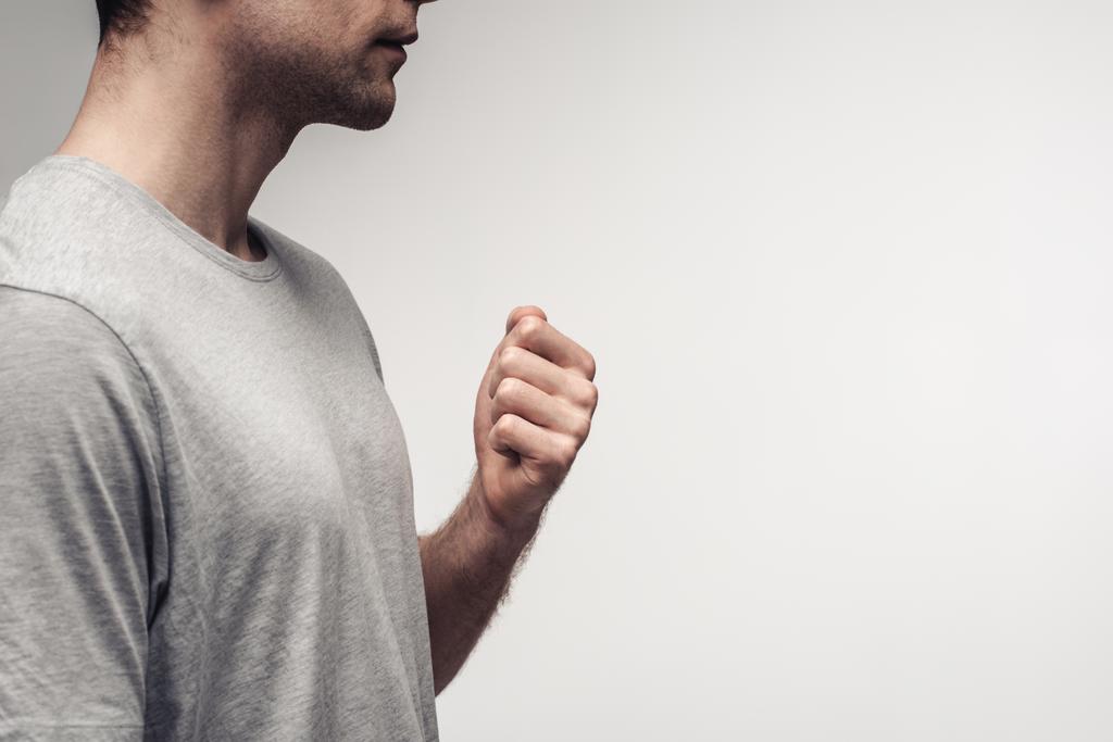 visão parcial do homem segurando punho ao usar a linguagem corporal isolada no conceito de cinza, emoção humana e expressão
 - Foto, Imagem