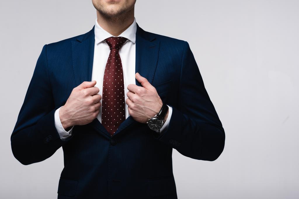 cropped view of confident businessman touching suit isolated on grey, human emotion and expression concept - Photo, Image