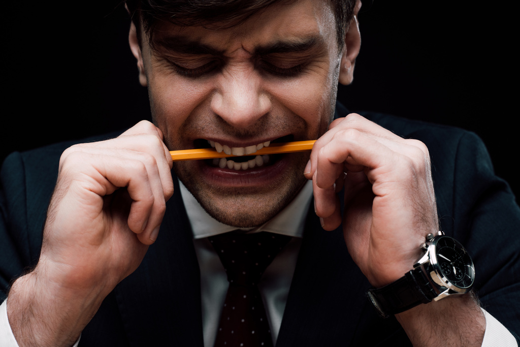hombre de negocios enojado mordiendo lápiz aislado en negro
 - Foto, imagen
