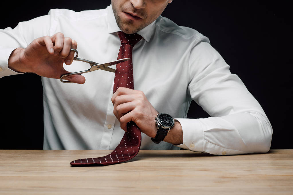 засмучений бізнесмен ріжуча краватка з ножицями ізольована на чорному
 - Фото, зображення