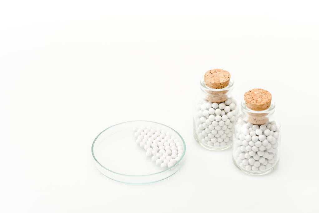 Flaschen mit Holzkorken in der Nähe von Glas-Petrischale isoliert auf weiß  - Foto, Bild