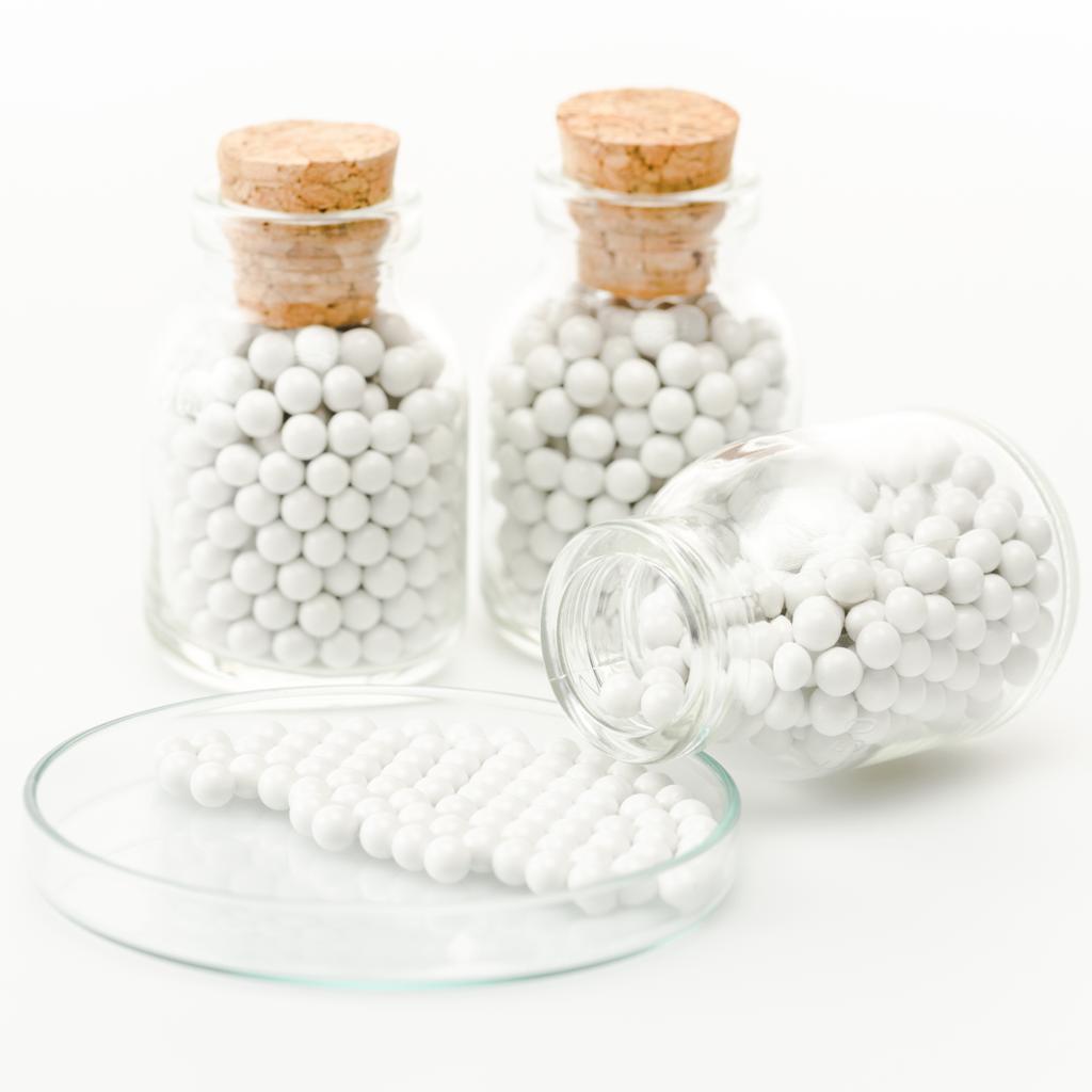 szelektív összpontosít palack kerek kis tabletták közelében üveg Petri-csészébe izolált fehér  - Fotó, kép