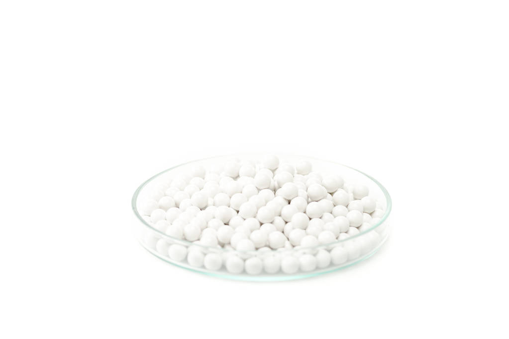 píldoras pequeñas redondas en placa de Petri de vidrio aislada en blanco
  - Foto, imagen
