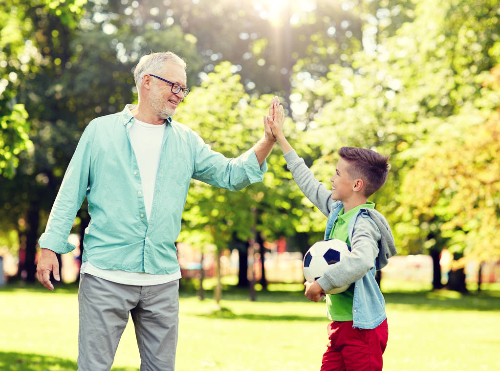 old man and boy with soccer ball making high five - Photo, Image