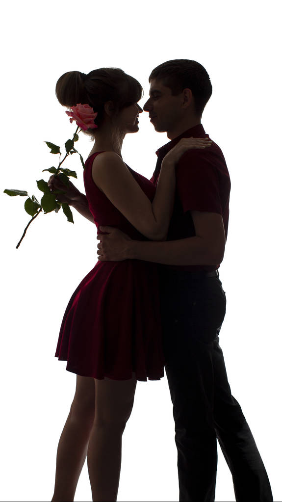 sylwetka młodej pary w miłości taniec na białym białym tle, człowiek przytulanie kobieta trzyma kwiat róży, romans koncepcji i daty - Zdjęcie, obraz